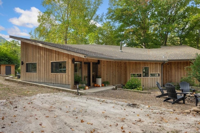 rear view of house featuring a patio and a fire pit