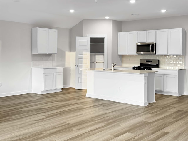3625 Wise Rd, Bryant, AR 72002 - kitchen featuring white cabinets, appliances with stainless steel finishes, light countertops, light wood-type flooring, and backsplash