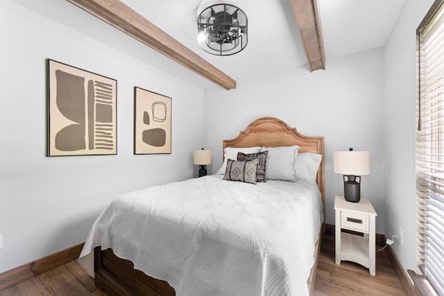 bedroom with baseboards, wood finished floors, a notable chandelier, and beamed ceiling