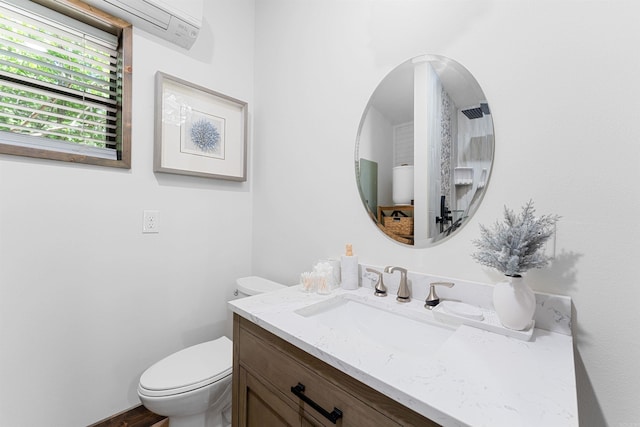 bathroom with vanity, an AC wall unit, and toilet