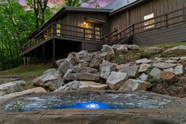 property exterior at dusk featuring a deck and metal roof