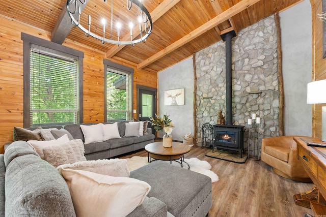 living area with wooden ceiling, lofted ceiling with beams, a wood stove, and wood finished floors