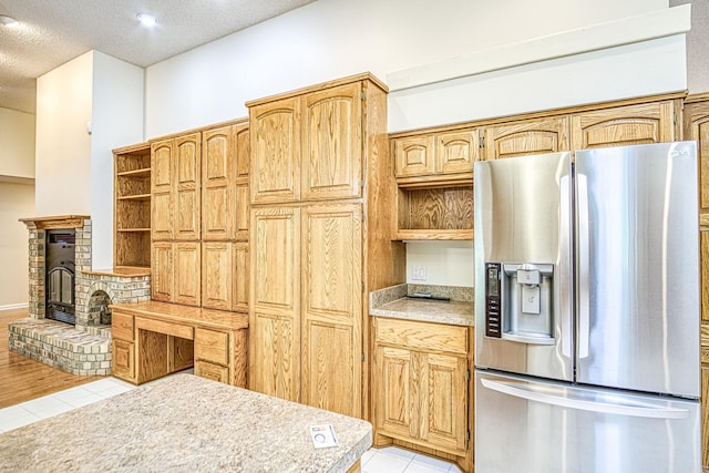 kitchen with light countertops, stainless steel refrigerator with ice dispenser, open shelves, and light tile patterned floors