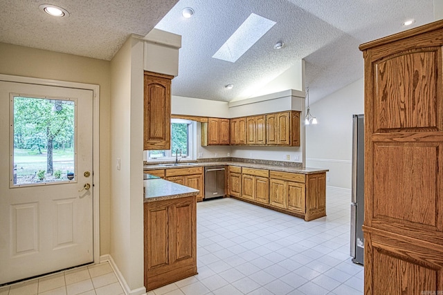kitchen featuring brown cabinets, a textured ceiling, appliances with stainless steel finishes, and a sink