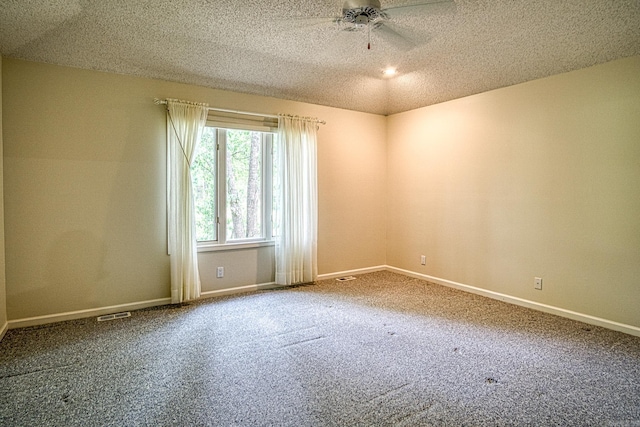 carpeted empty room featuring baseboards, ceiling fan, and visible vents