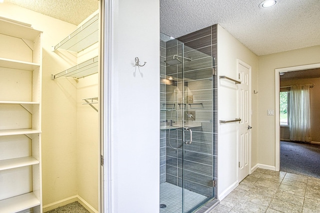 full bathroom featuring a textured ceiling and a shower stall