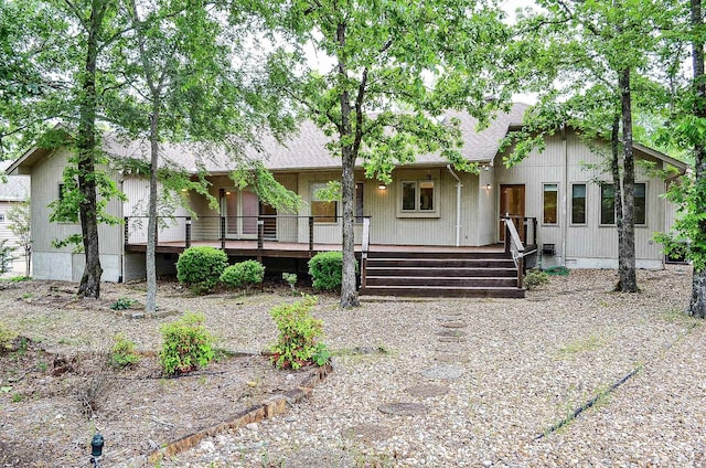 view of front of property with a shingled roof and a wooden deck