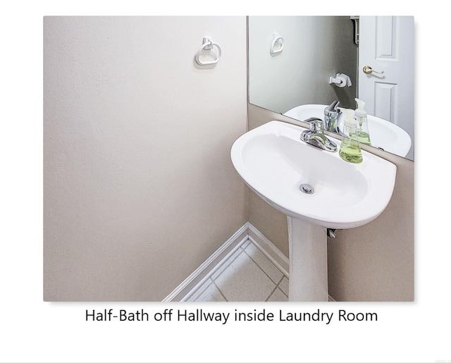 bathroom with a sink, baseboards, and tile patterned floors