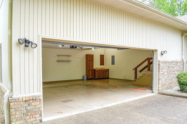 garage featuring driveway, a garage door opener, and electric panel
