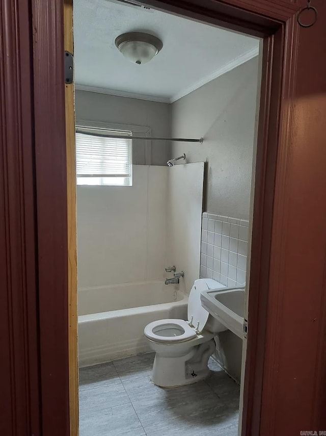 bathroom with ornamental molding, bathtub / shower combination, and toilet