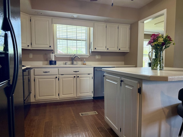 kitchen featuring visible vents, freestanding refrigerator, light countertops, a sink, and dishwasher