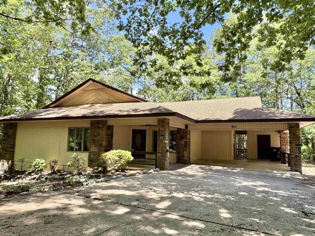 50 Monovar Cir, Hot Springs Village, AR 71909 - view of front of home featuring stone siding, driveway, roof with shingles, and a carport