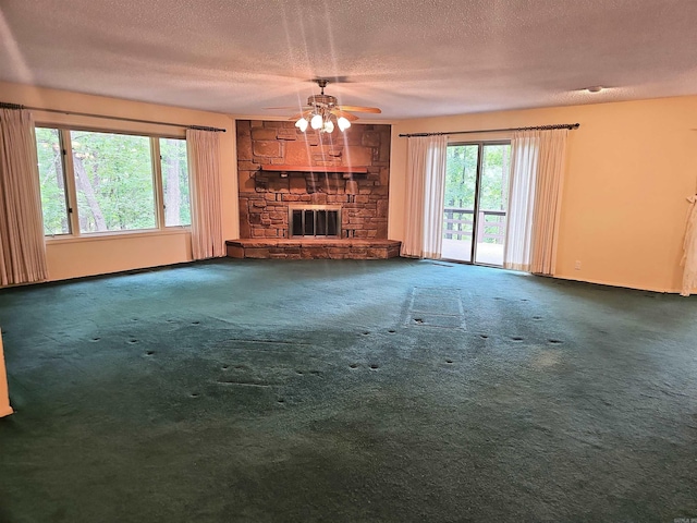 50 Monovar Cir, Hot Springs Village, AR 71909 - unfurnished living room featuring ceiling fan, a textured ceiling, carpet flooring, a stone fireplace, and baseboards