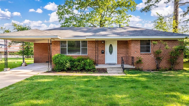 single story home with concrete driveway, an attached carport, a front yard, and brick siding