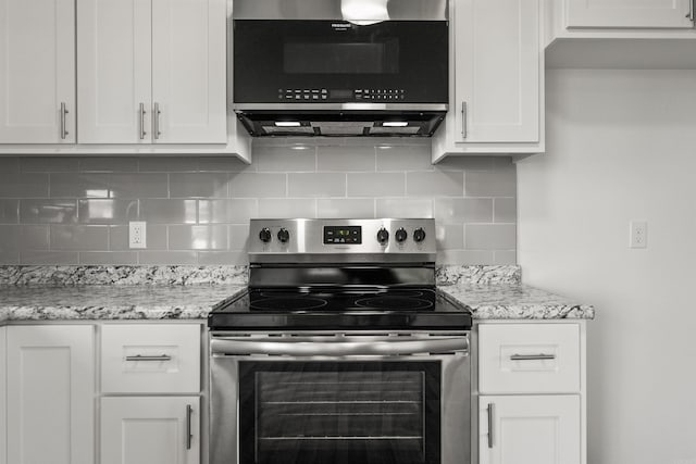 kitchen featuring backsplash, white cabinetry, appliances with stainless steel finishes, and light stone counters