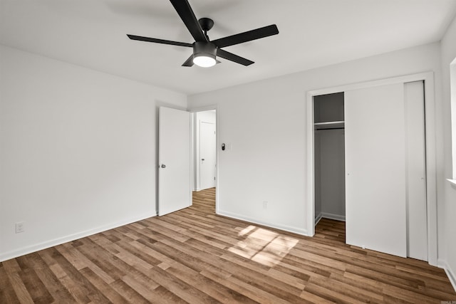unfurnished bedroom with a closet, baseboards, ceiling fan, and wood finished floors