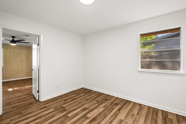 unfurnished room with baseboards, a ceiling fan, wood finished floors, and visible vents