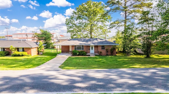 view of front facade with brick siding, a front yard, an attached carport, and concrete driveway