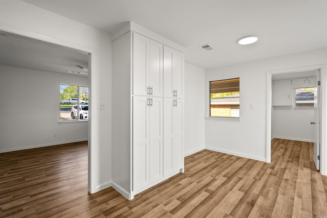 interior space with baseboards, a closet, light wood finished floors, and visible vents