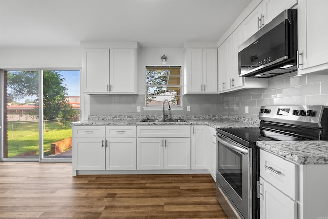 kitchen featuring a sink, appliances with stainless steel finishes, white cabinets, and a wealth of natural light