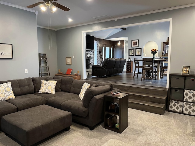 carpeted living room with ornamental molding, a ceiling fan, and visible vents