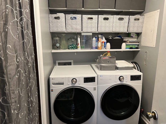washroom with laundry area, washer and clothes dryer, and electric panel