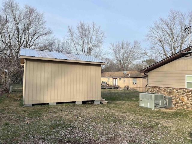 view of shed featuring central air condition unit and fence