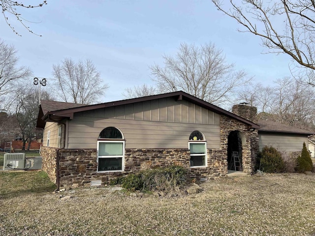 view of side of property with a chimney and stone siding