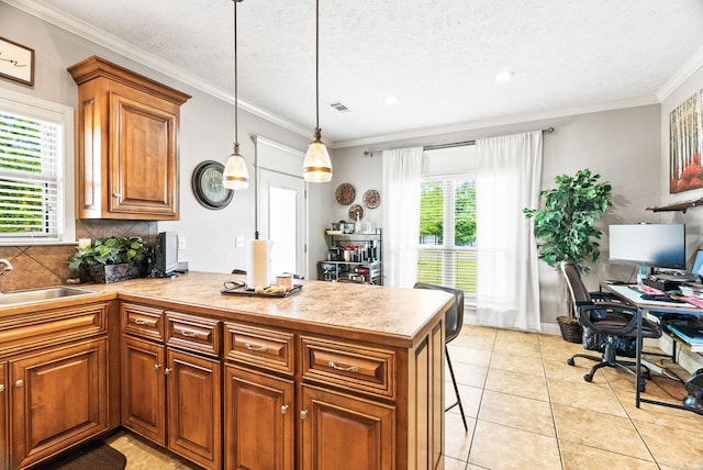 kitchen featuring a peninsula, visible vents, a wealth of natural light, and a sink