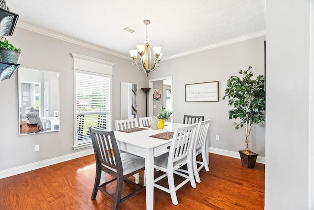 dining space featuring visible vents, crown molding, wood finished floors, baseboards, and a notable chandelier