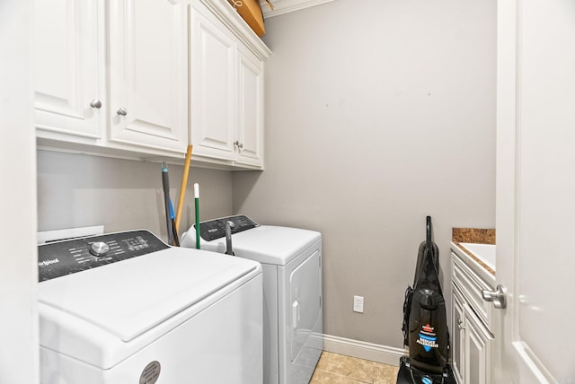 clothes washing area featuring baseboards, washer and clothes dryer, cabinet space, and light tile patterned flooring