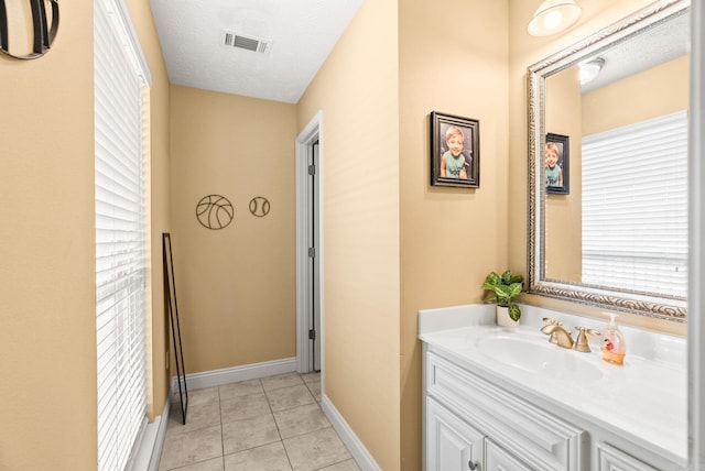 bathroom with visible vents, baseboards, tile patterned floors, and vanity