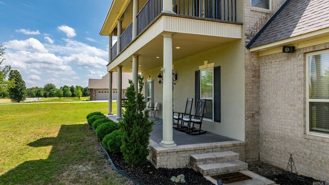 exterior space featuring a porch, a garage, brick siding, a yard, and stucco siding