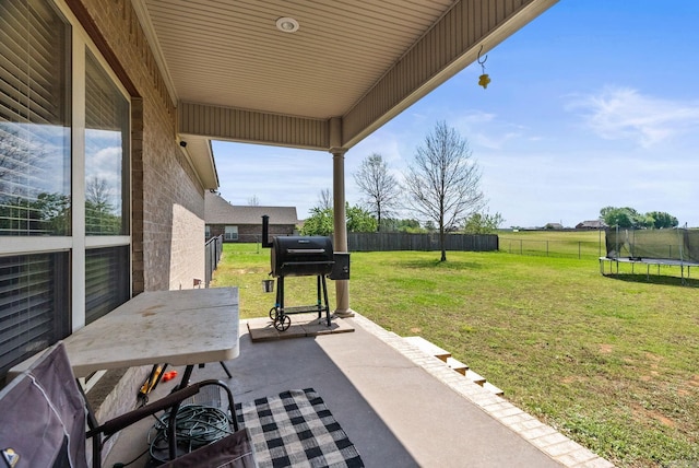 view of patio featuring a fenced backyard, a trampoline, and grilling area