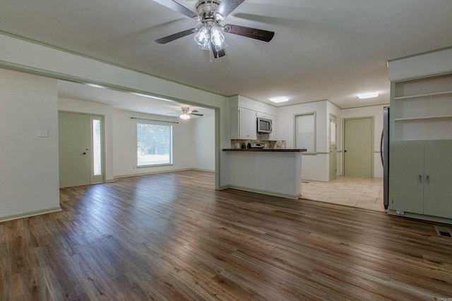 unfurnished living room with a ceiling fan and light wood-style floors