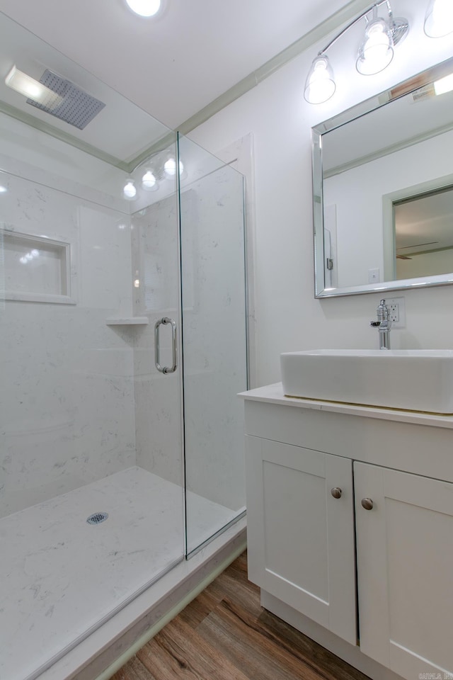 full bathroom featuring visible vents, a shower stall, wood finished floors, and vanity