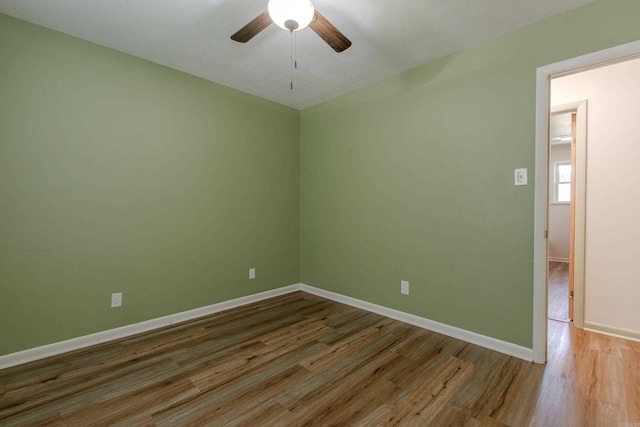 unfurnished room featuring a ceiling fan, baseboards, and wood finished floors