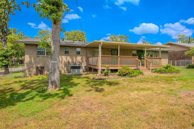 back of house with fence, cooling unit, a yard, and brick siding
