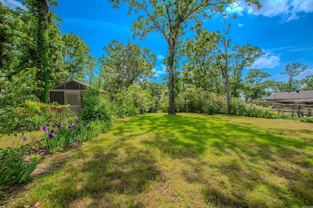 view of yard featuring fence and an outdoor structure