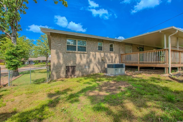back of house featuring a lawn, a deck, a gate, central air condition unit, and fence