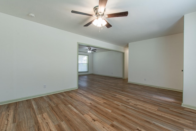 unfurnished room featuring light wood-style floors, baseboards, and a ceiling fan