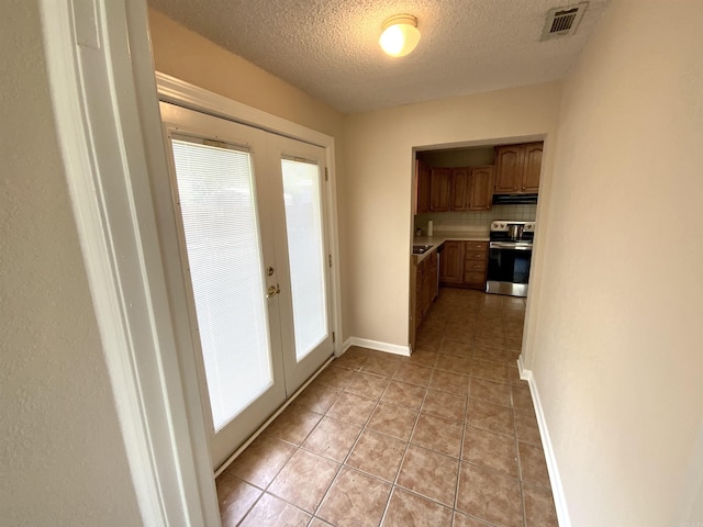 1101 S 8th St, Heber Springs, AR 72543 - doorway with visible vents, light tile patterned flooring, baseboards, a textured ceiling, and french doors