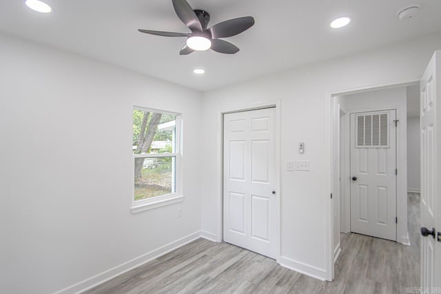 unfurnished bedroom with recessed lighting, baseboards, a closet, and light wood-type flooring