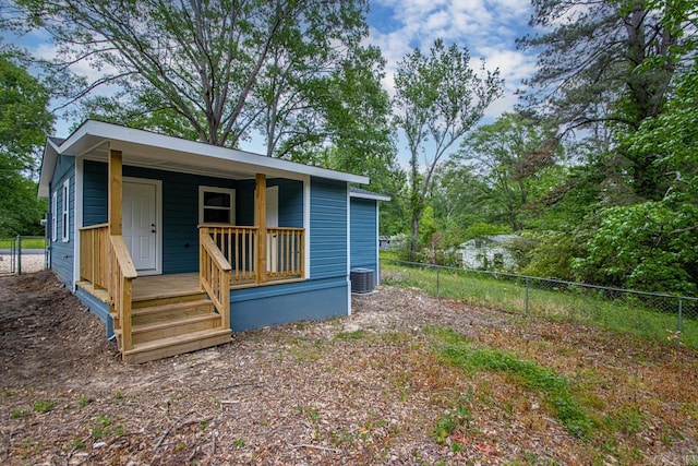 view of outdoor structure featuring a porch, fence, and cooling unit