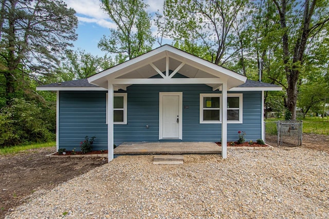 bungalow-style house featuring a porch and roof with shingles