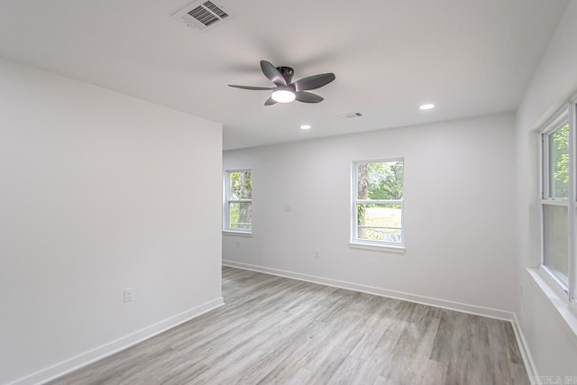 spare room with visible vents, light wood-style floors, ceiling fan, and baseboards