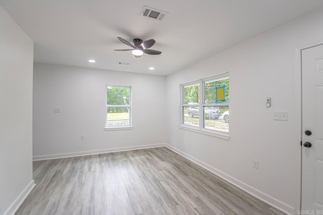 spare room with ceiling fan, visible vents, baseboards, and light wood-style floors