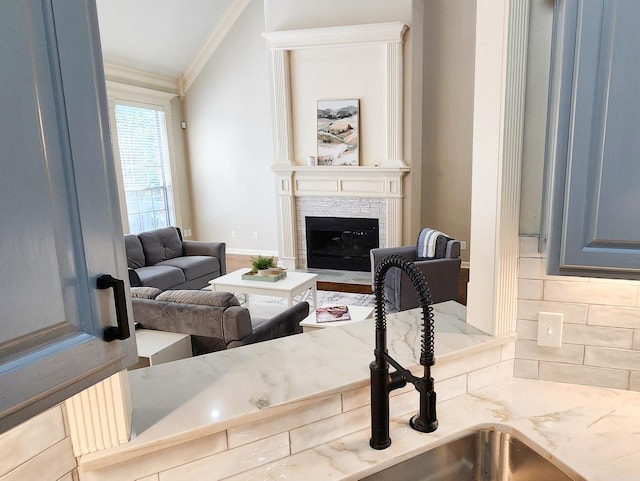 living room with crown molding and a fireplace with flush hearth