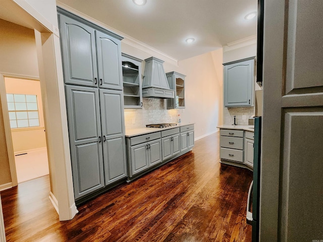 kitchen with gray cabinetry, backsplash, custom exhaust hood, and dark wood-style floors