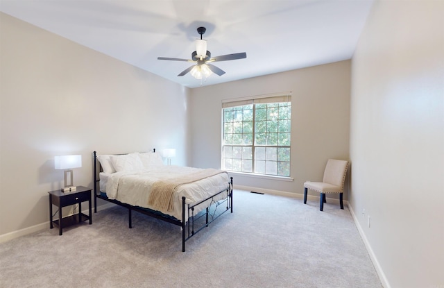 bedroom with light colored carpet, baseboards, and ceiling fan